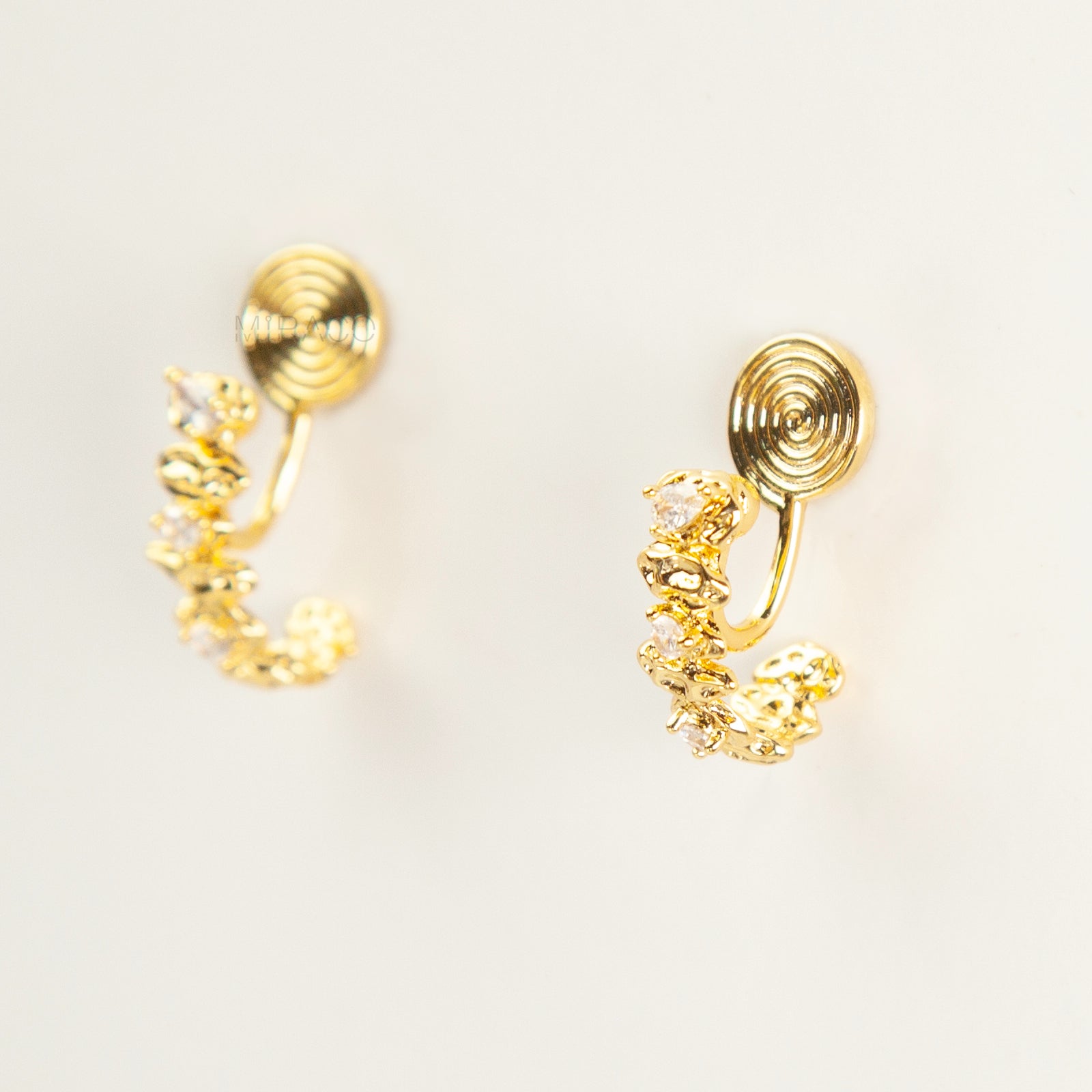 Gold-tone dangle clip-on earrings featuring stacked clear stones and a secure coil-back closure.