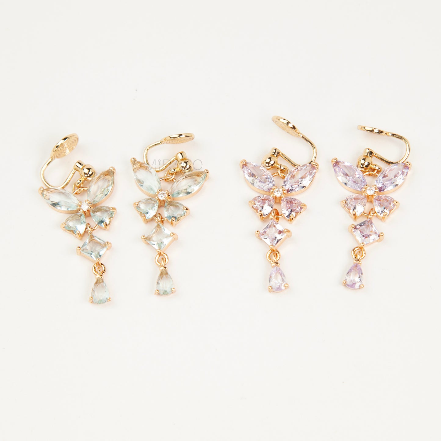 A pair of gold-tone, coil-back clip-on dangle earrings featuring a butterfly cluster of multifaceted Serene Aquamarine (pale blue) crystals and cascading drop stones.