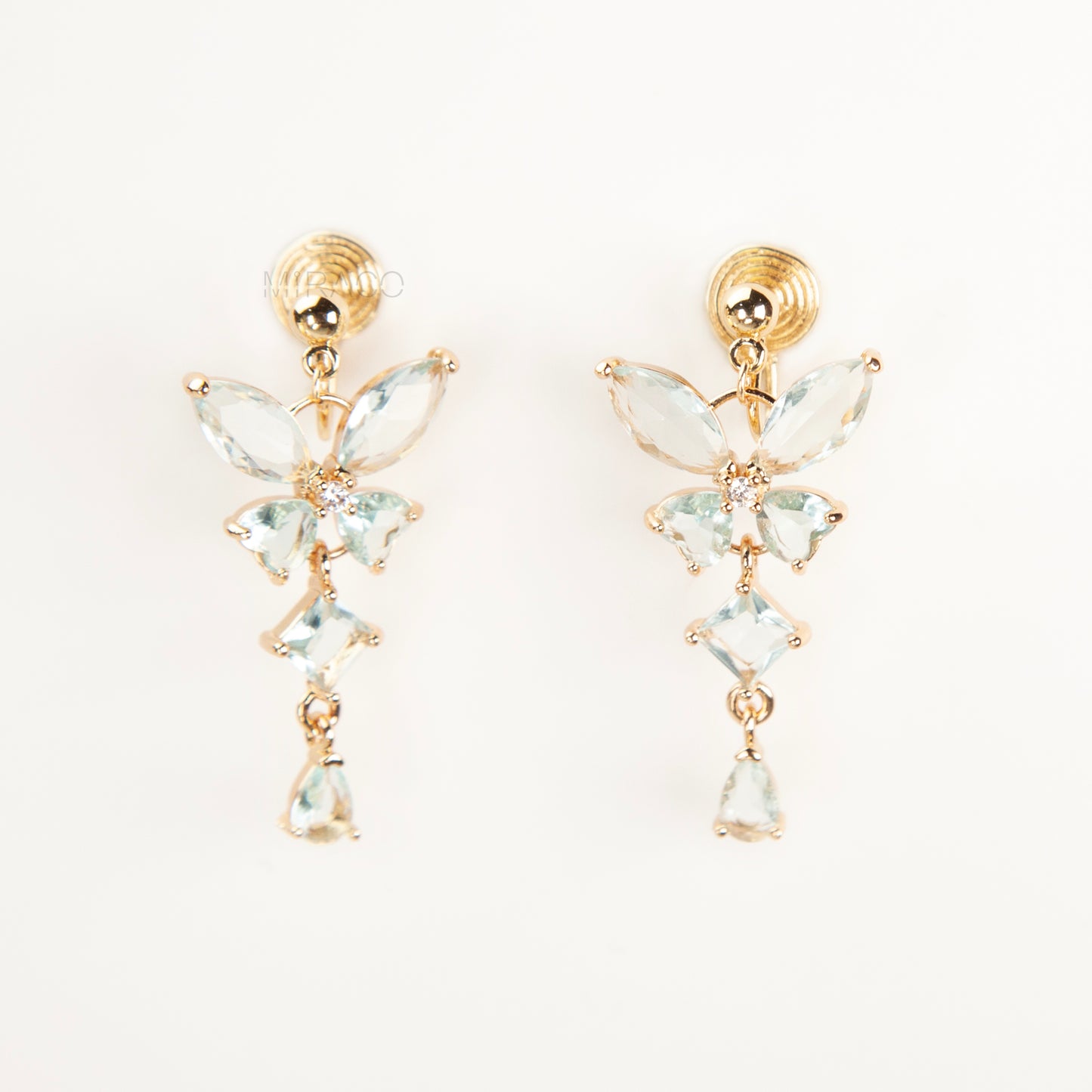 A pair of gold-tone, coil-back clip-on dangle earrings featuring a butterfly cluster of multifaceted Serene Aquamarine (pale blue) crystals and cascading drop stones.