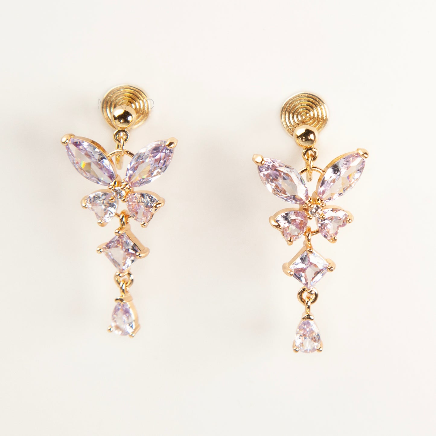 A pair of gold-tone, coil-back clip-on dangle earrings featuring a butterfly cluster of multifaceted Serene Aquamarine (pale blue) crystals and cascading drop stones.