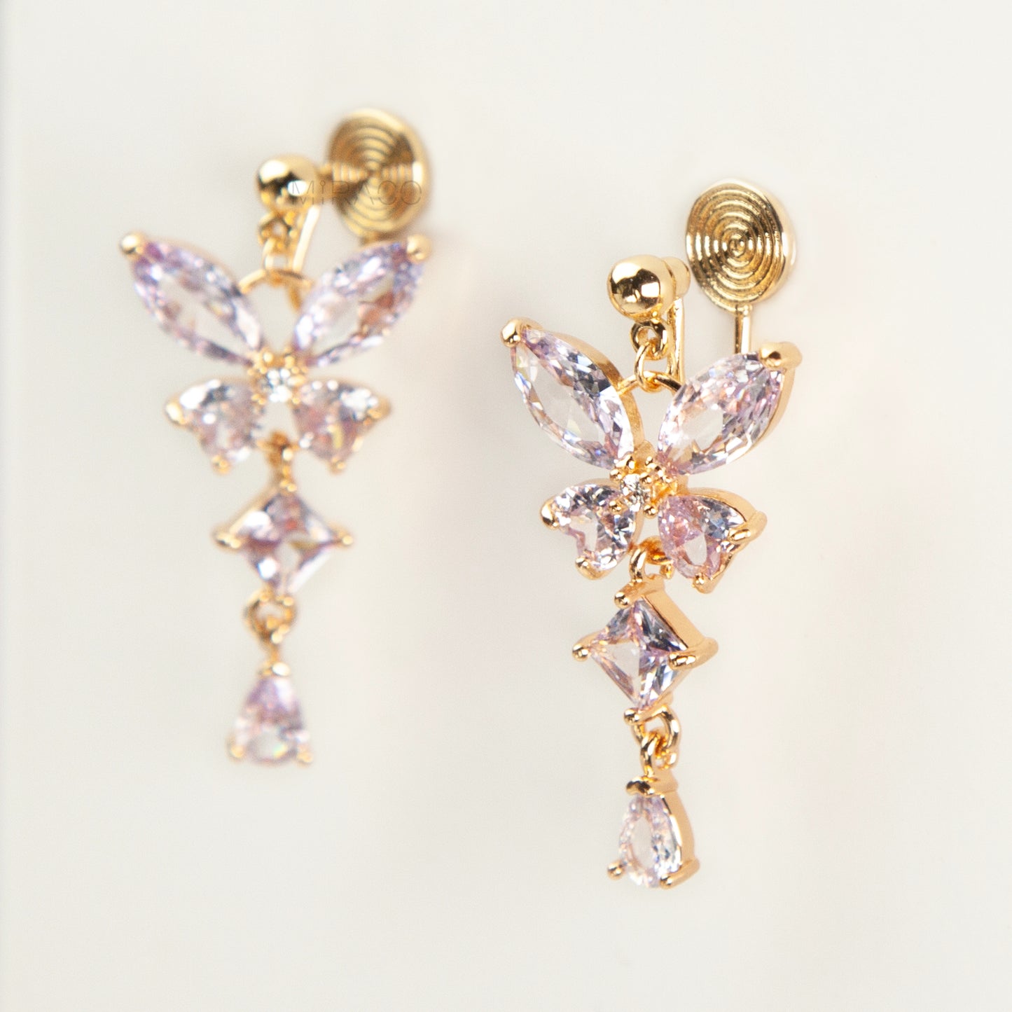 A pair of gold-tone, coil-back clip-on dangle earrings featuring a butterfly cluster of multifaceted Serene Aquamarine (pale blue) crystals and cascading drop stones.