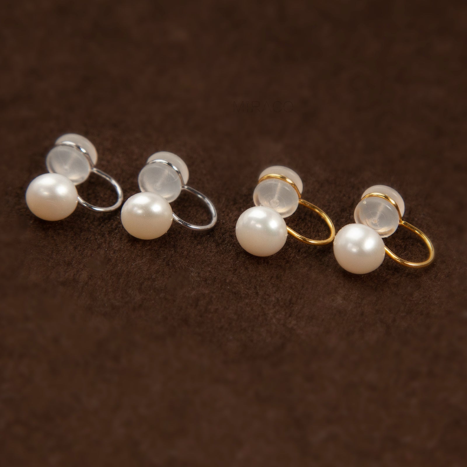 round freshwater pearl clip-on earrings with clear silicone comfort backs, shown in both gold-plated and silver-plated finishes on a white background.