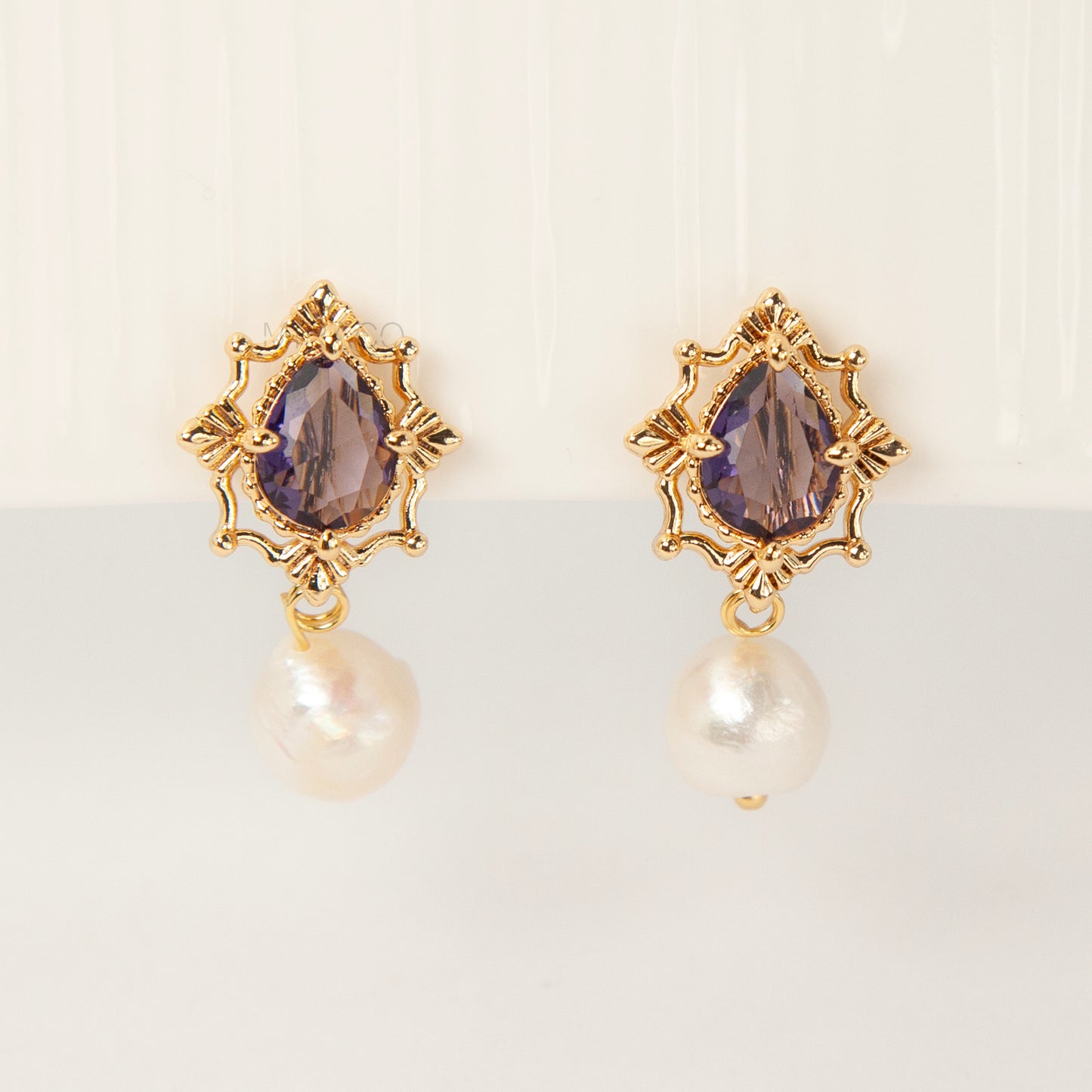 Pair of gold-plated, coil-back clip-on earrings with an ornate Victorian-style setting holding a purple pear-cut gemstone (amethyst color) and a dangling real baroque freshwater pearl.