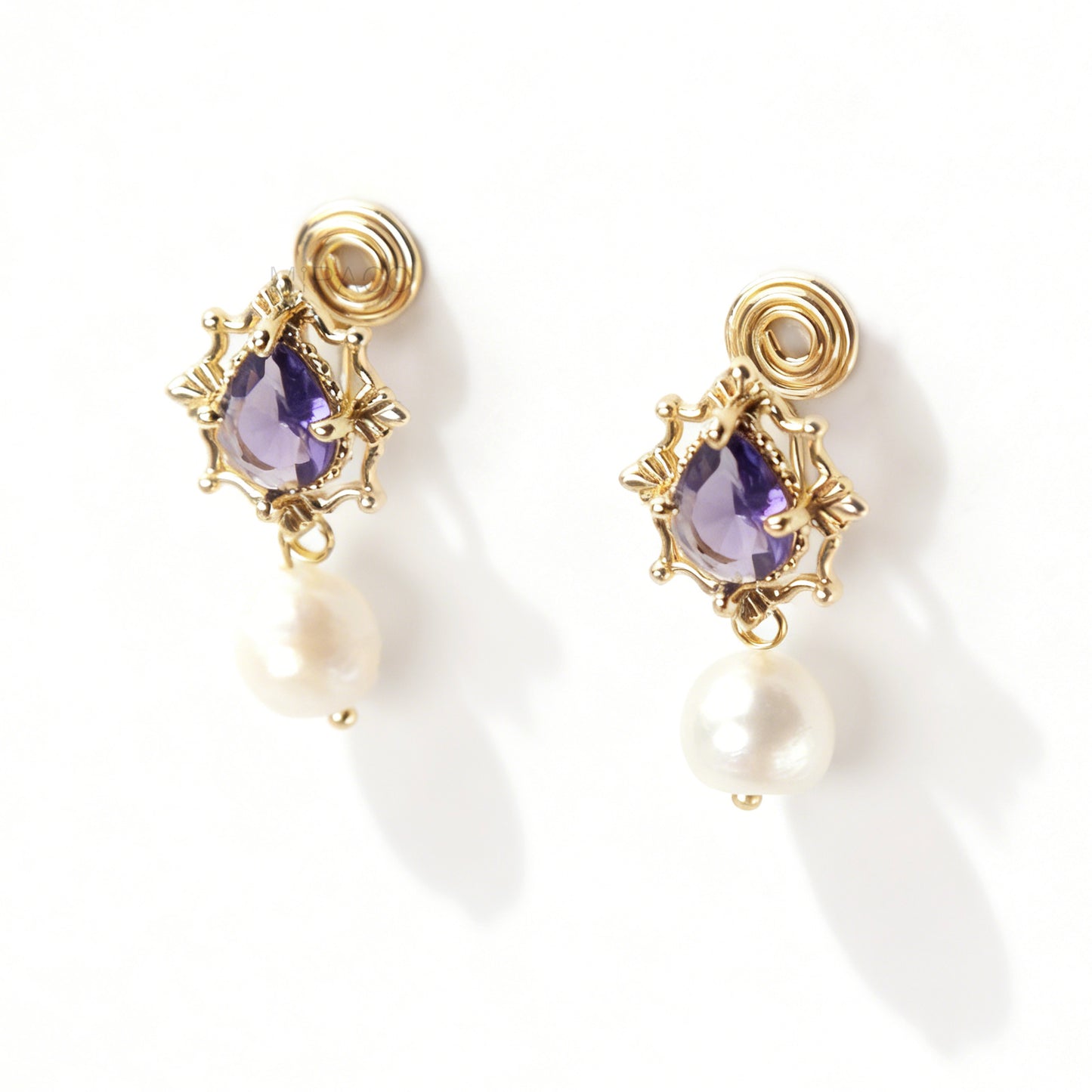 Pair of gold-plated, coil-back clip-on earrings with an ornate Victorian-style setting holding a purple pear-cut gemstone (amethyst color) and a dangling real baroque freshwater pearl.