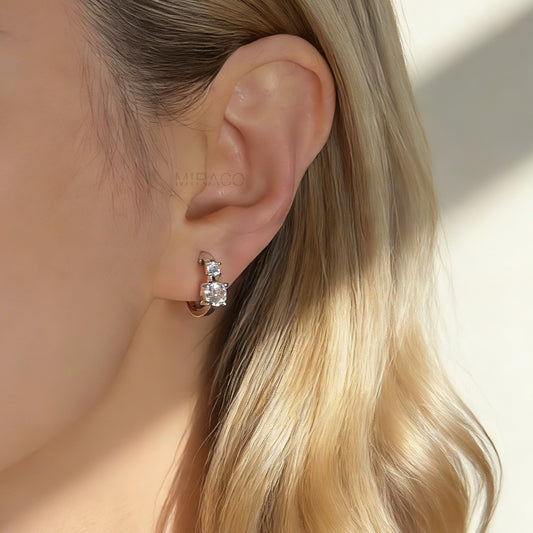 Silver clip-on hoop earrings featuring two clear square CZ stones with round silicone back