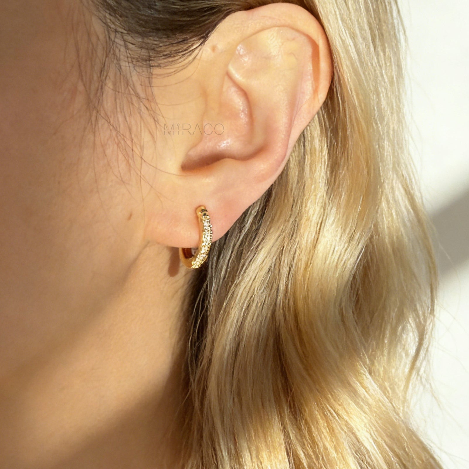 Gold clip-on hoop earrings with sparkling pave diamonds and coil back clips