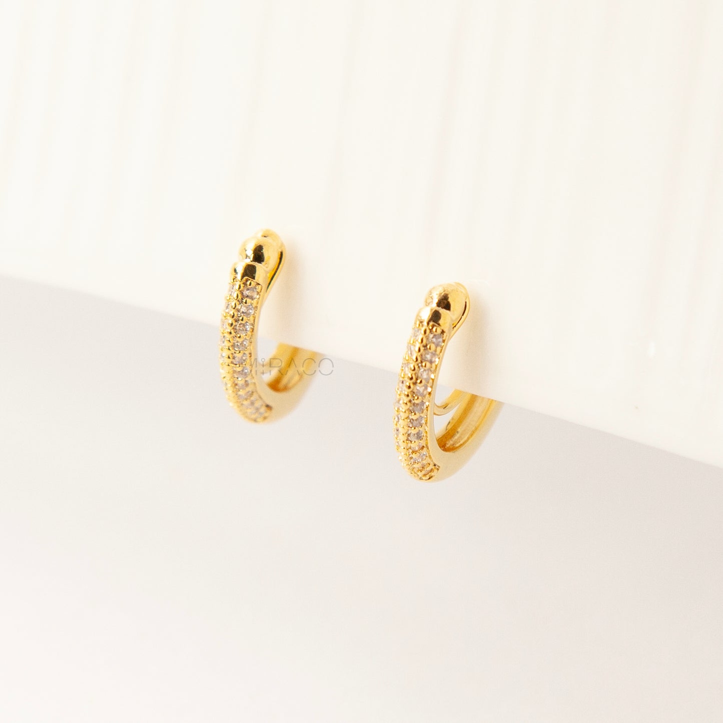 Gold clip-on hoop earrings with sparkling pave diamonds and coil back clips