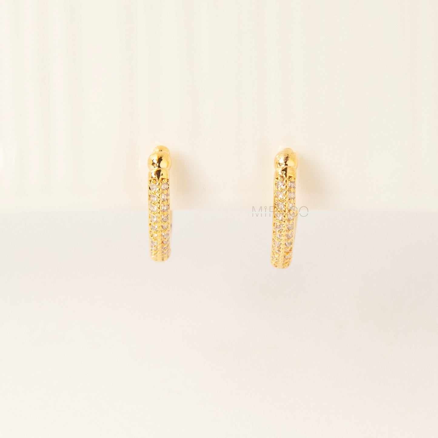 Gold clip-on hoop earrings with sparkling pave diamonds and coil back clips