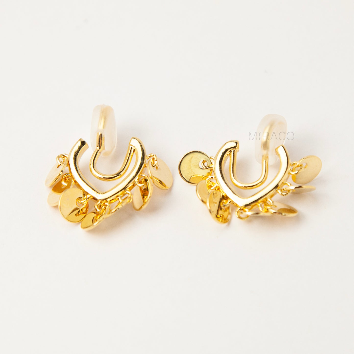 Gold U-shaped clip-on earrings with dangling coin charms and comfortable coil back design for non-pierced ears