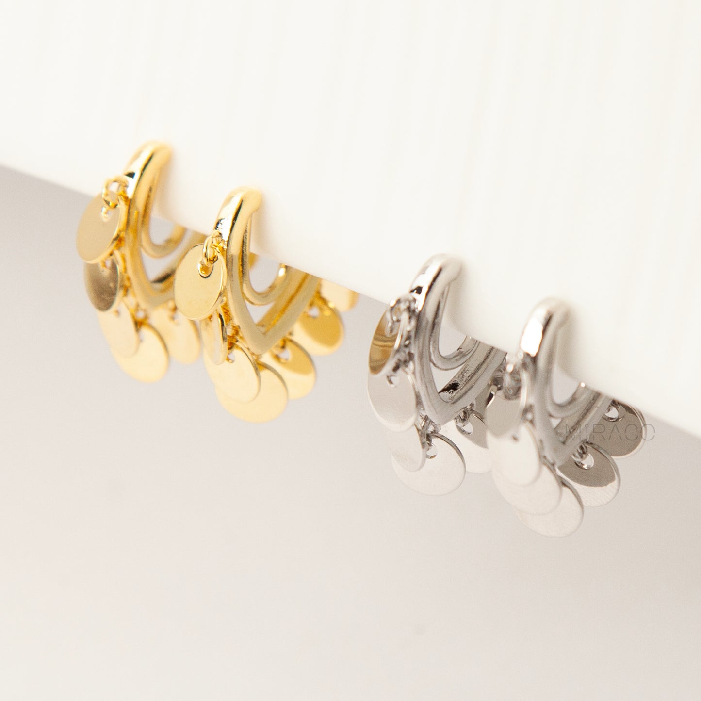 Gold and silver U-shaped clip-on earrings with dangling coin charms and comfortable coil back design for non-pierced ears
