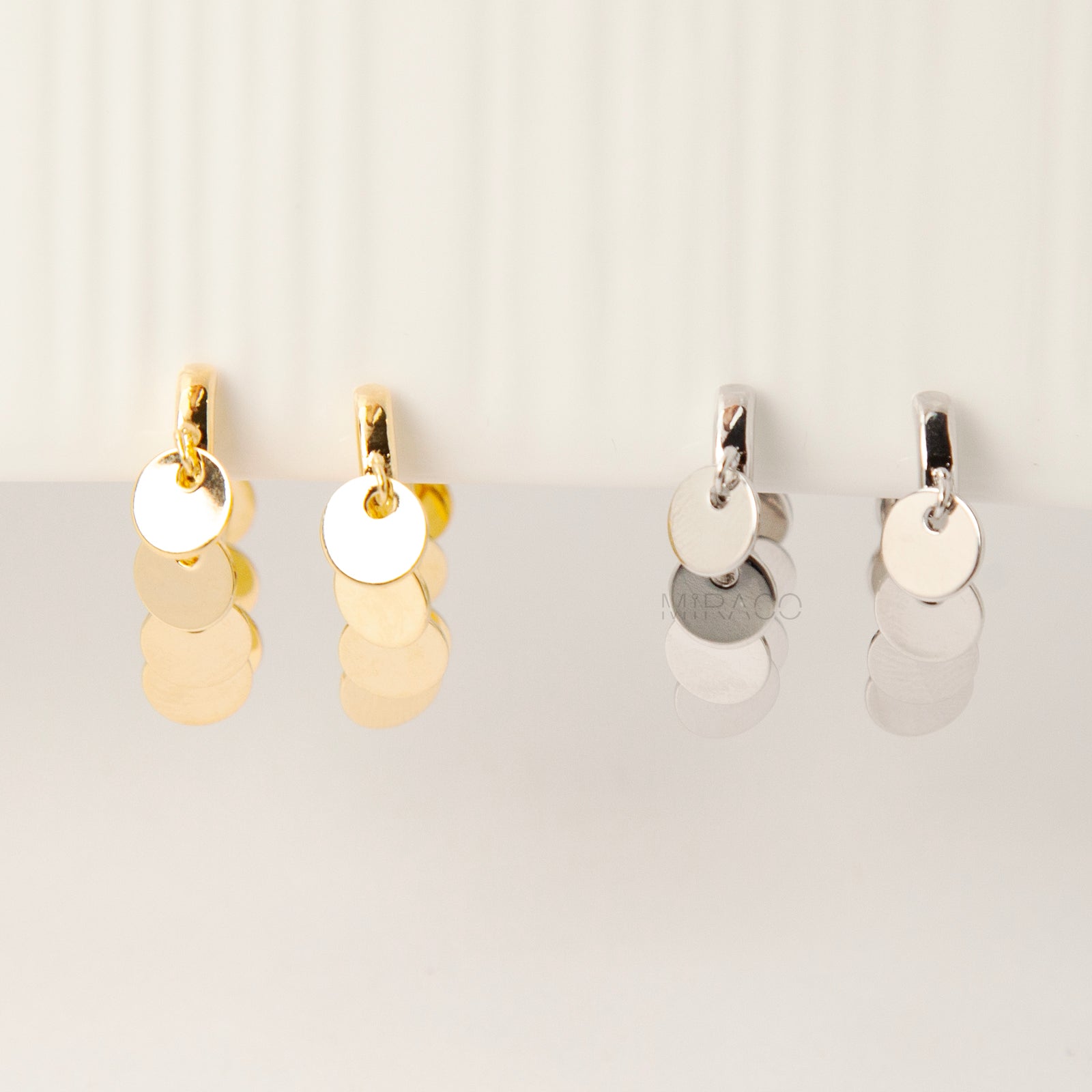 Gold and silver U-shaped clip-on earrings with dangling coin charms and comfortable coil back design for non-pierced ears