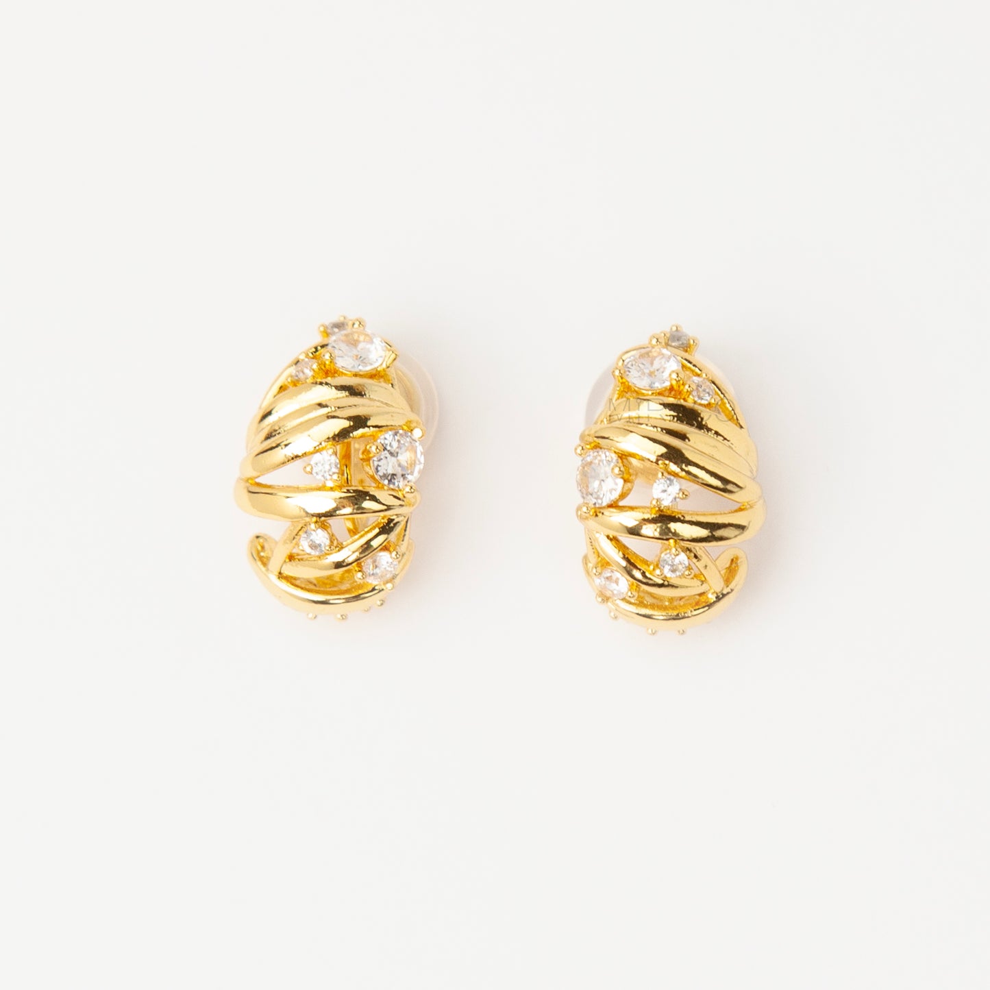 Gold clip-on earrings with wrapped sculptural design and clear crystal accents, featuring a comfortable coil back for non-pierced ears