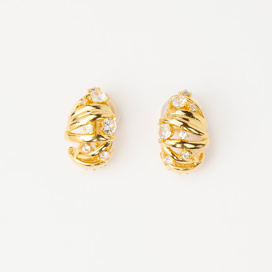 Gold clip-on earrings with wrapped sculptural design and clear crystal accents, featuring a comfortable coil back for non-pierced ears