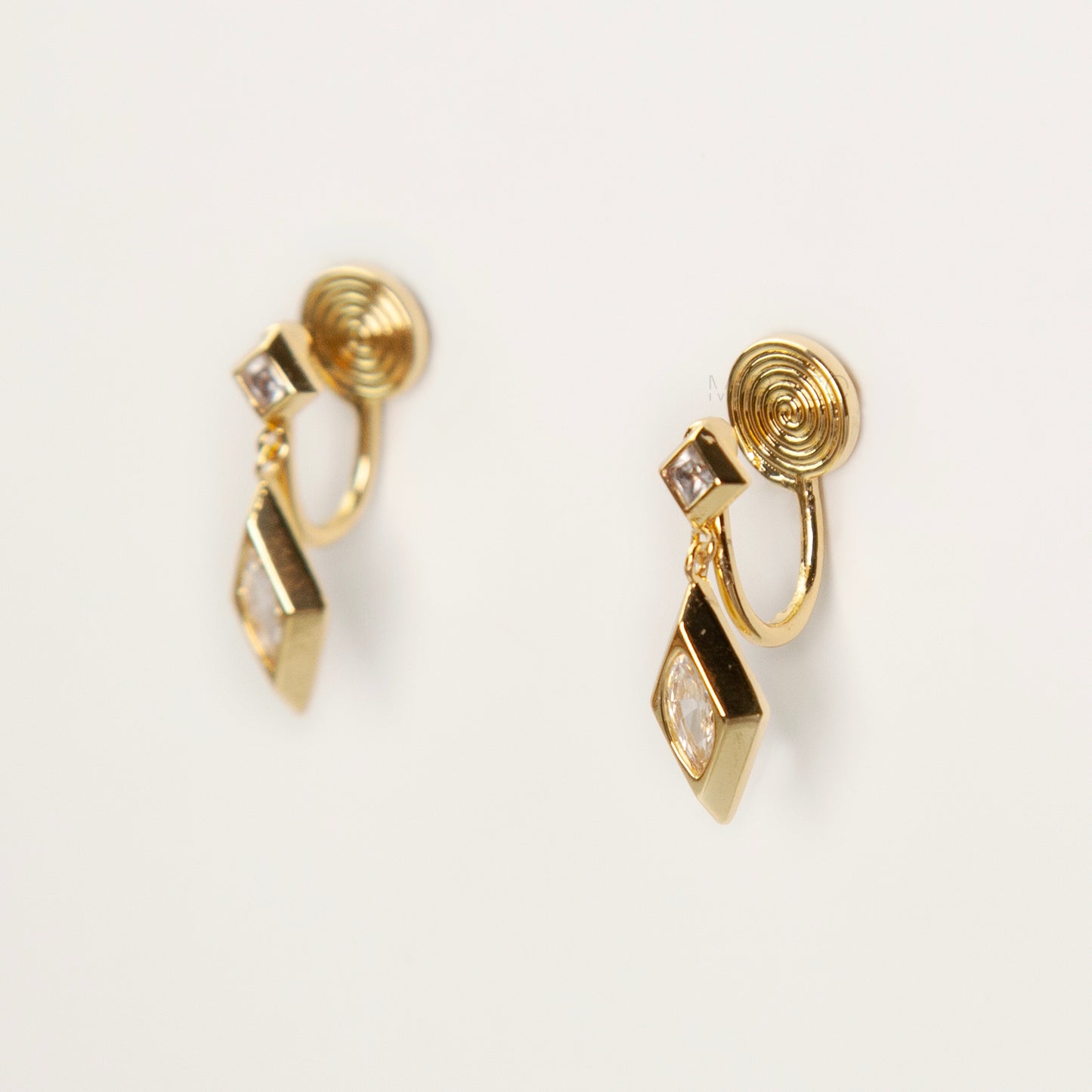 Pair of gold-tone geometric drop clip-on earrings featuring a small square crystal and a larger marquise-cut crystal dangle with comfortable coil-back closures.