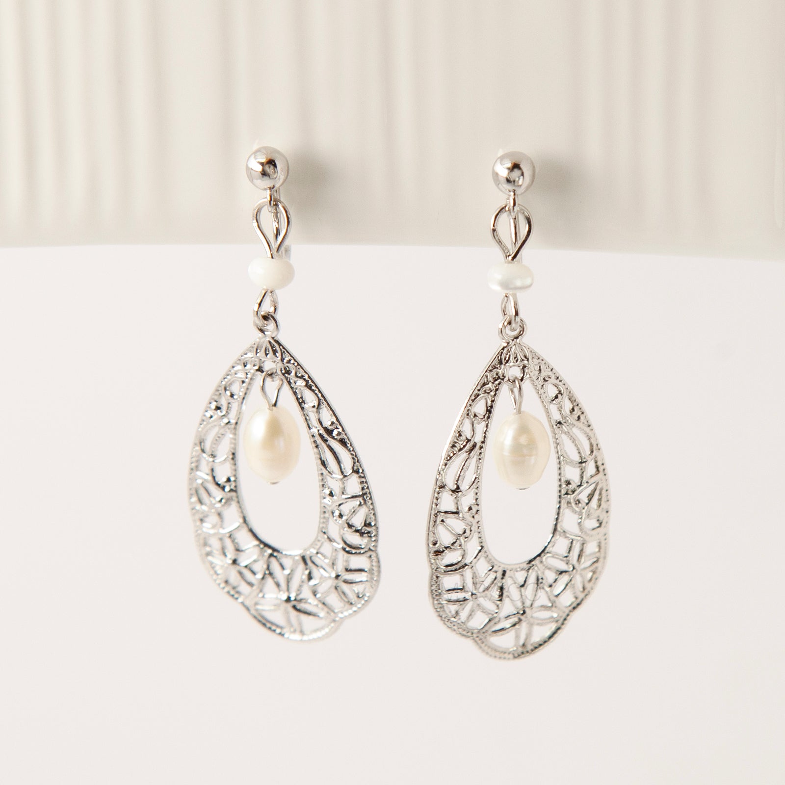 Silver filigree teardrop clip-on earrings with freshwater pearl drop and comfortable coil back for non-pierced ears