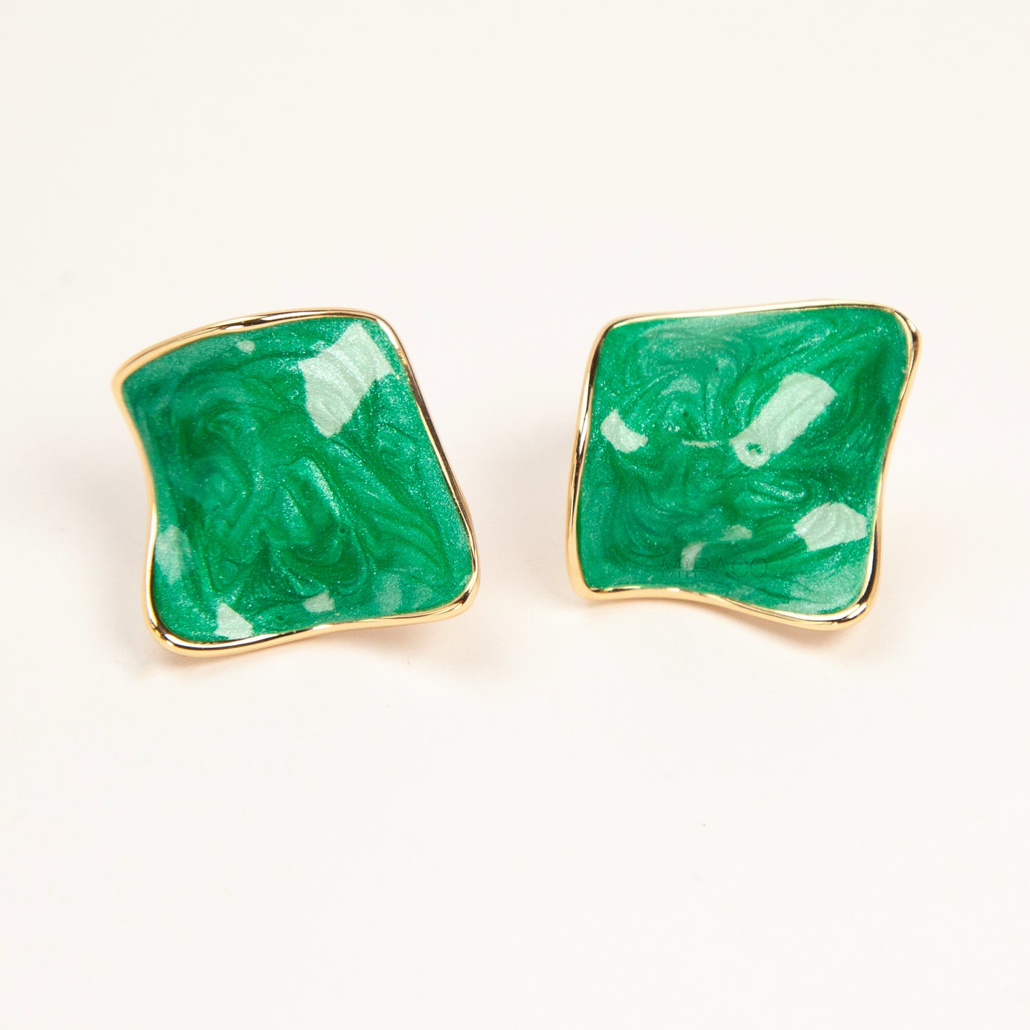 Pair of square-shaped emerald green marbled enamel clip-on earrings with gold-tone edges and comfortable coil back closures.