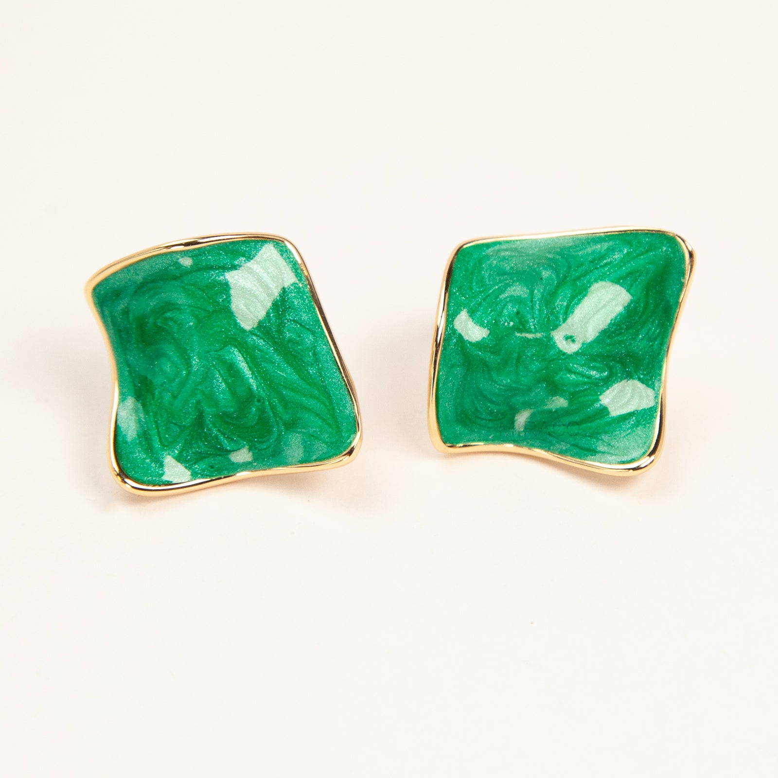 Pair of square-shaped emerald green marbled enamel clip-on earrings with gold-tone edges and comfortable coil back closures.
