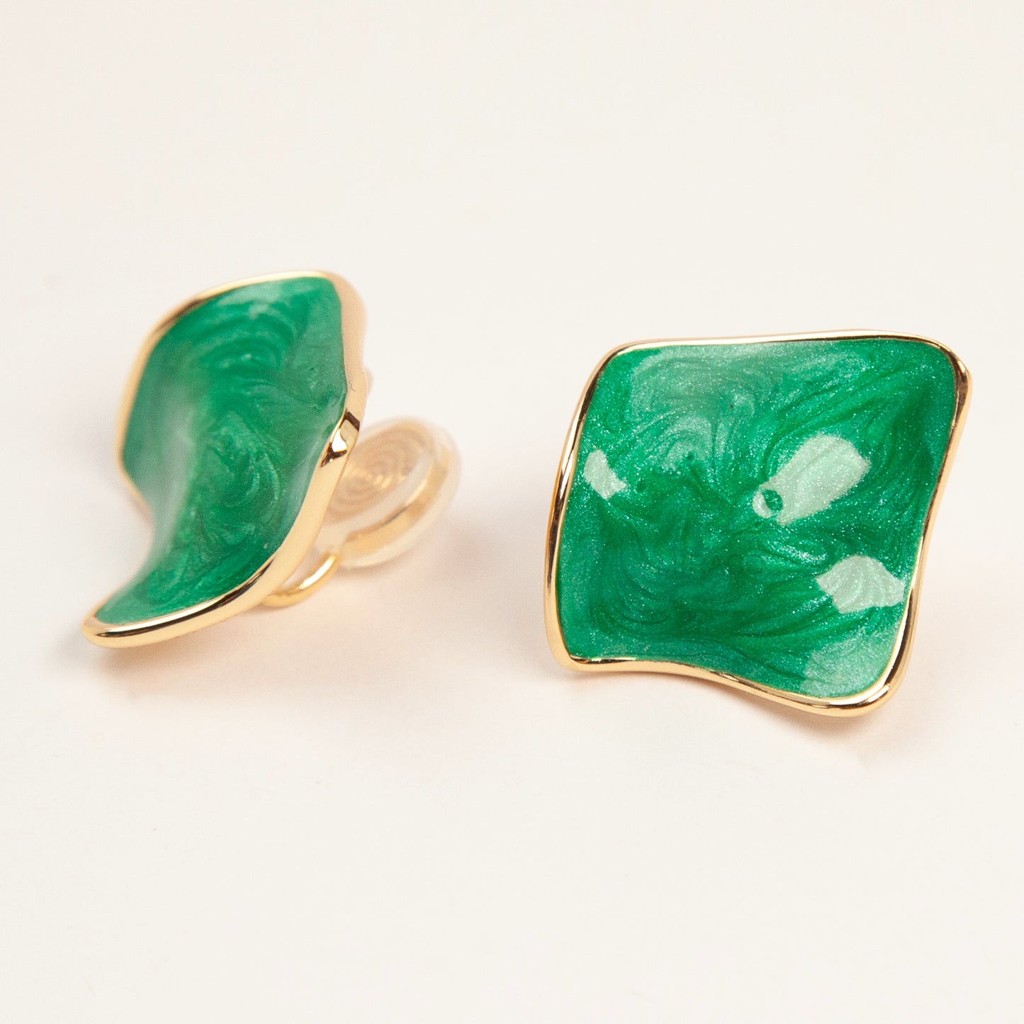 Pair of square-shaped emerald green marbled enamel clip-on earrings with gold-tone edges and comfortable coil back closures.