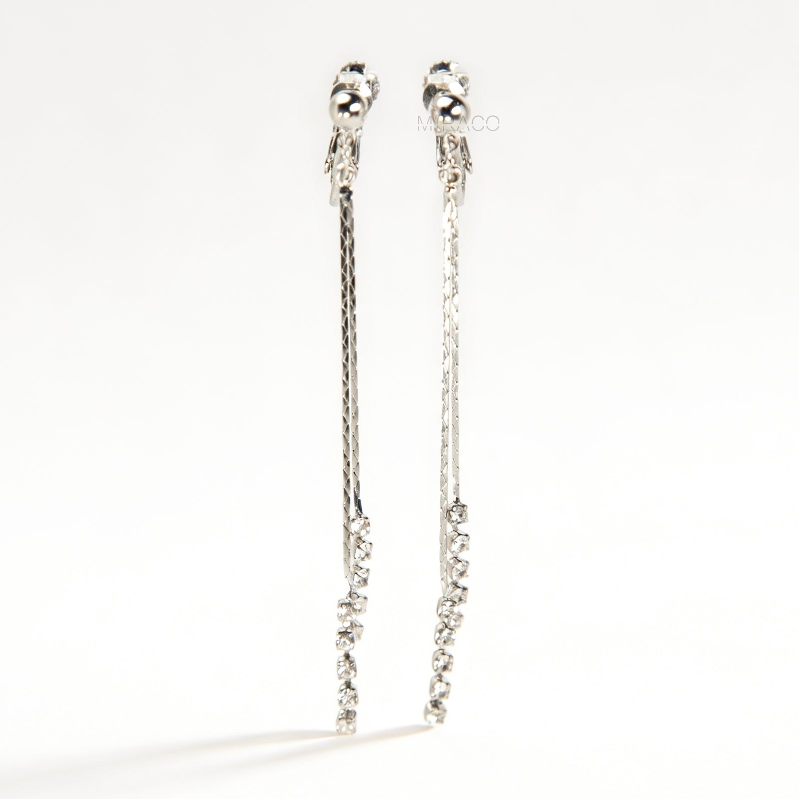 Pair of silver double-strand linear drop clip-on earrings with crystal tips and adjustable screw-back closures on a white background.