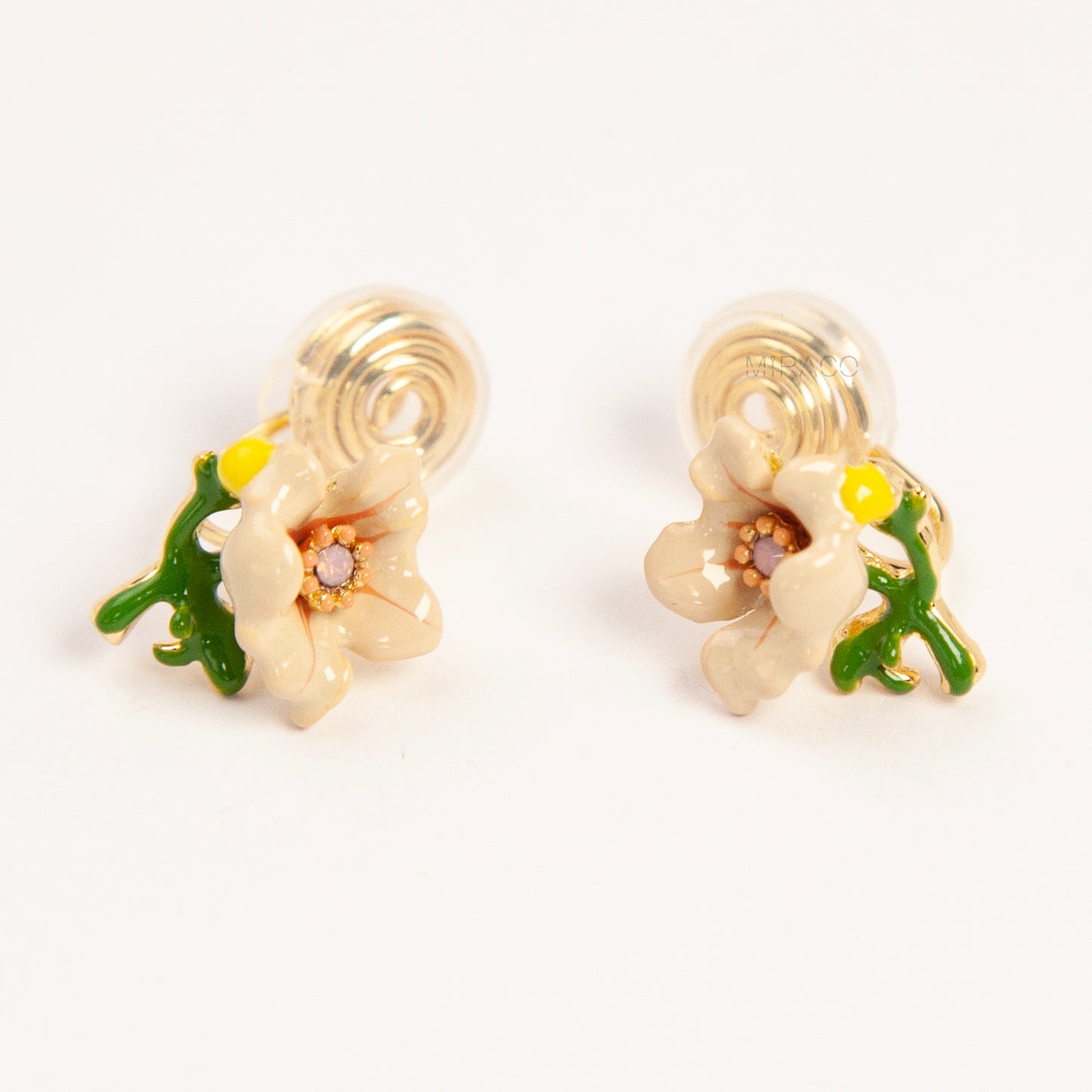 Pair of cream-colored enamel flower clip-on earrings with green stems and invisible gold-tone coil back closures on a white background.