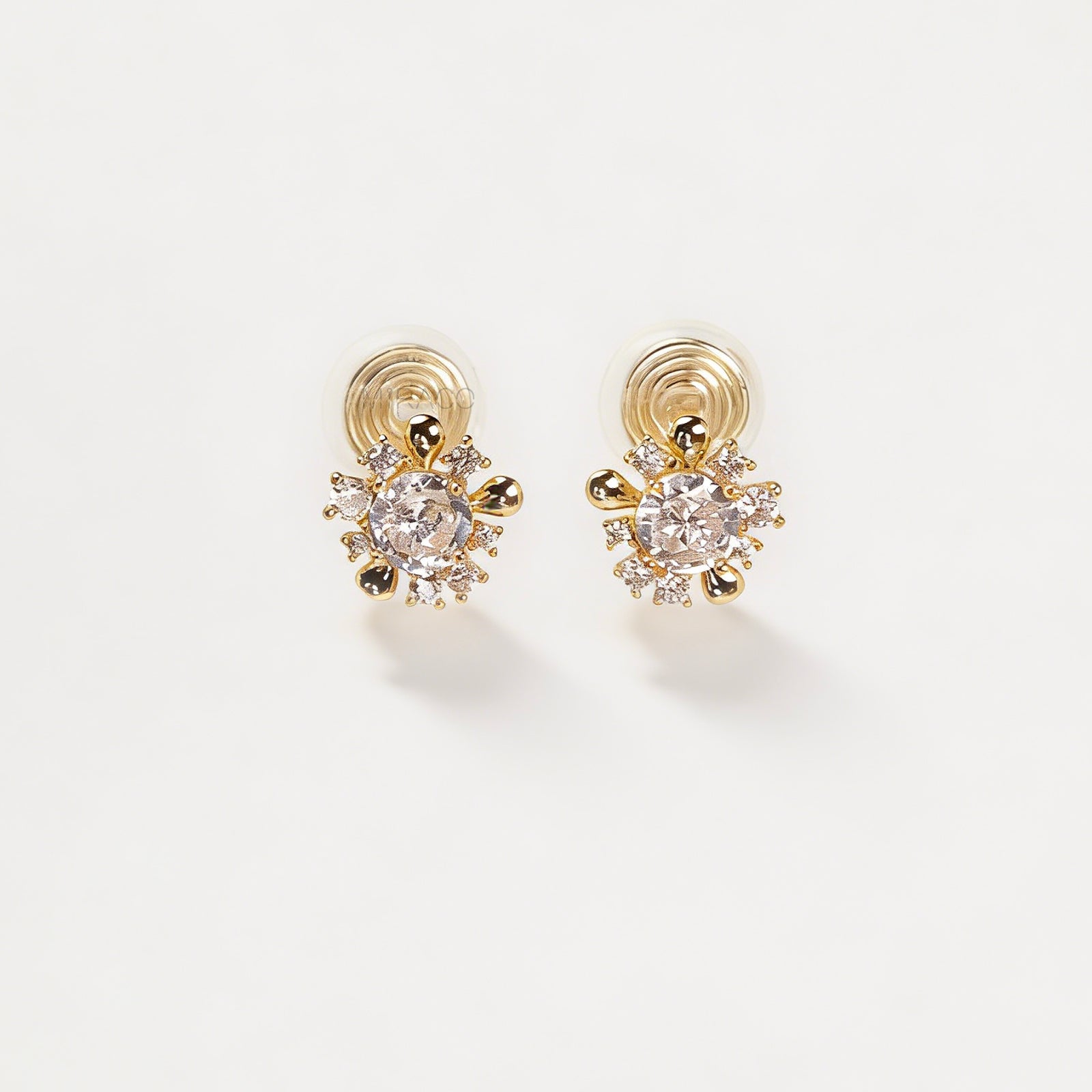 Pair of gold-tone sunburst-shaped clip-on earrings with a central cubic zirconia stone and comfortable invisible coil back closures.