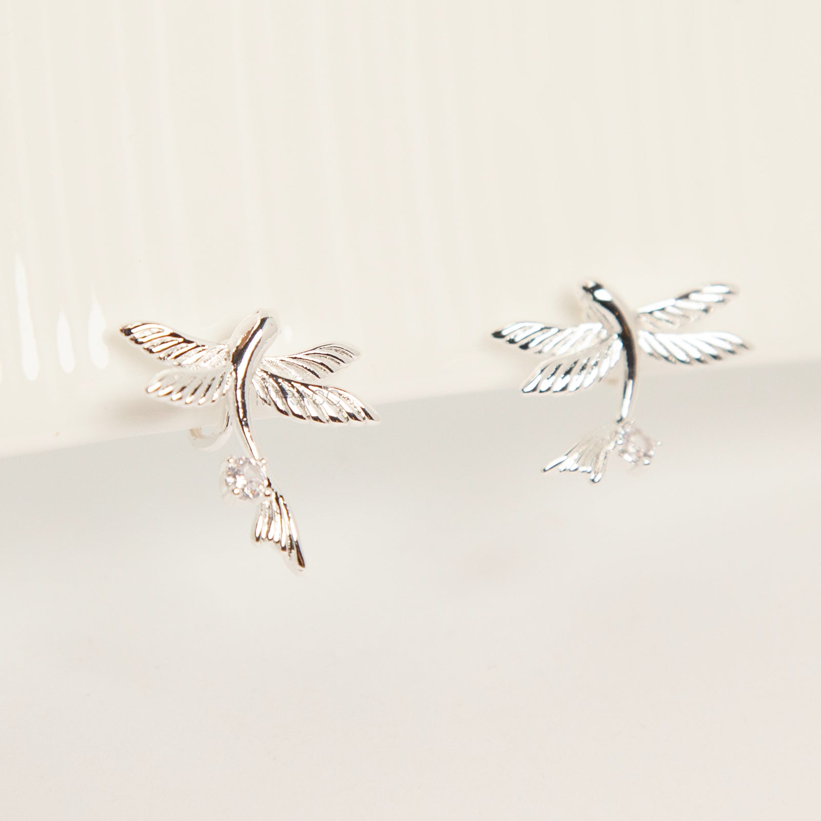 Pair of silver-tone bird-shaped clip-on earrings in flight with clear crystals and comfortable invisible coil back closures.