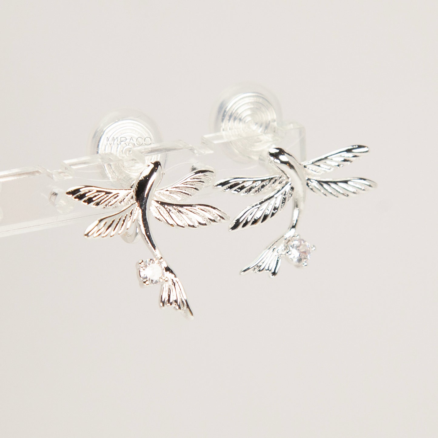 Pair of silver-tone bird-shaped clip-on earrings in flight with clear crystals and comfortable invisible coil back closures.