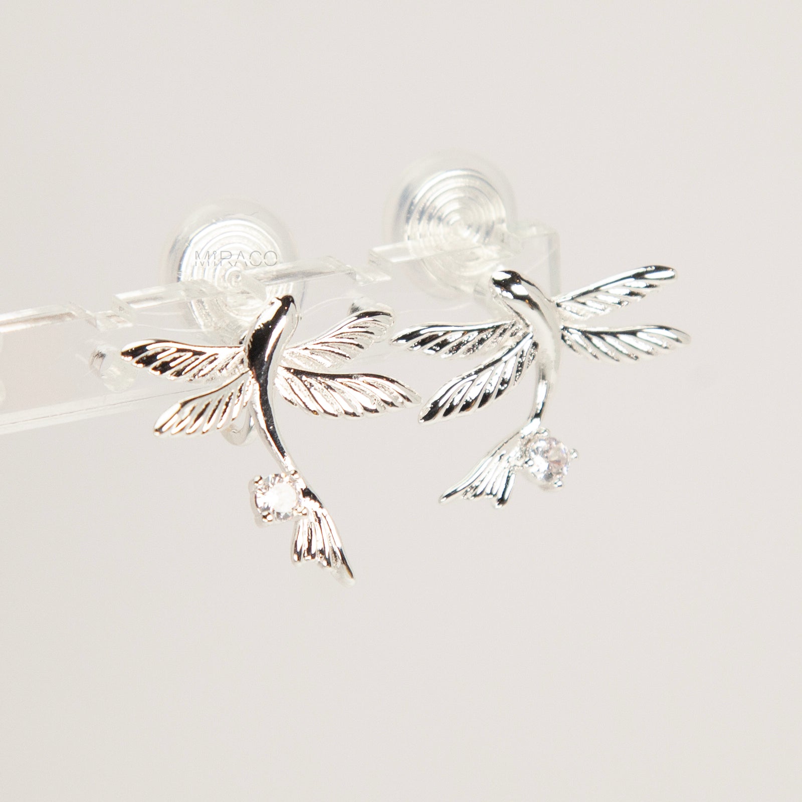 Pair of silver-tone bird-shaped clip-on earrings in flight with clear crystals and comfortable invisible coil back closures.