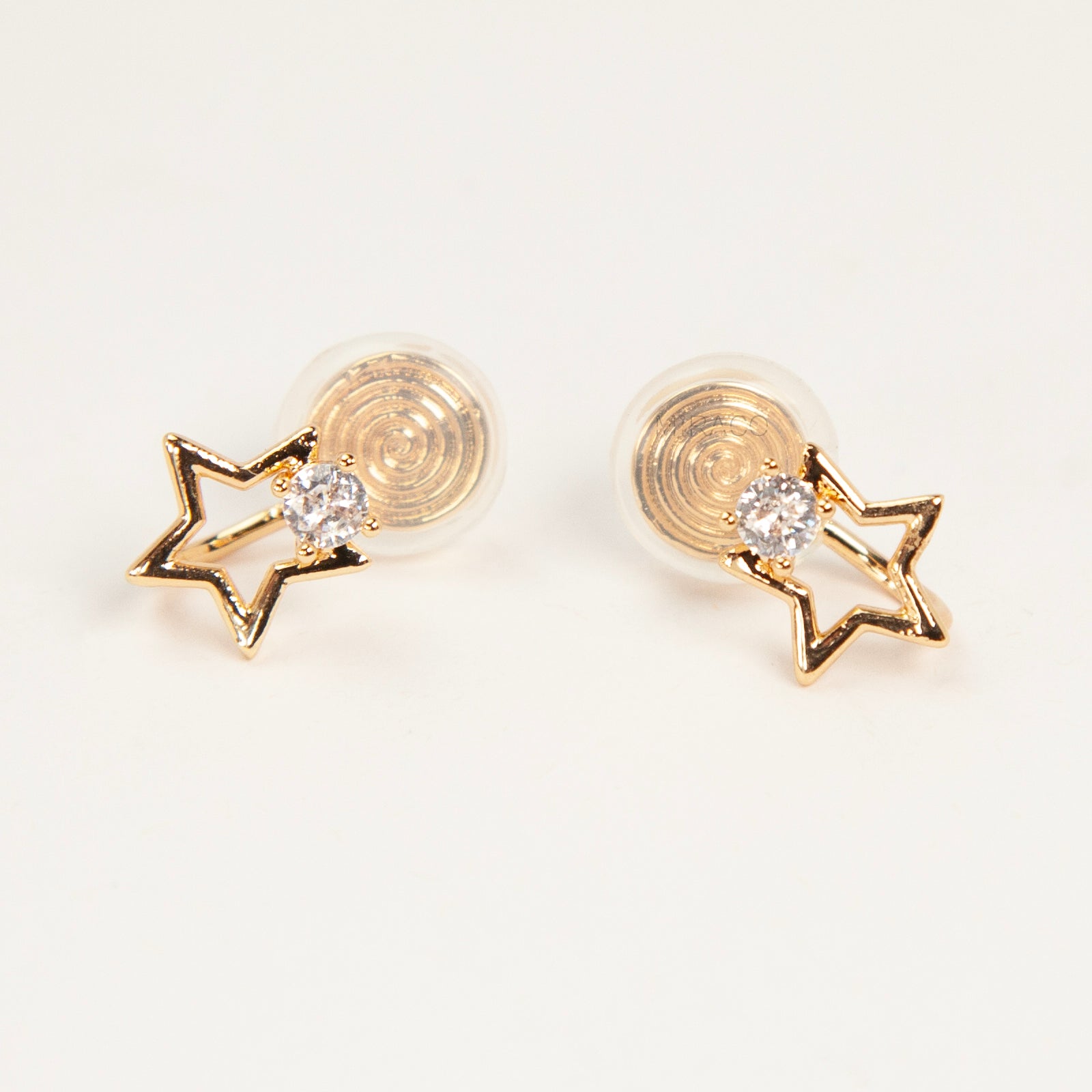 Pair of gold-tone open star-shaped clip-on earrings featuring a small clear crystal and comfortable invisible coil back closures.