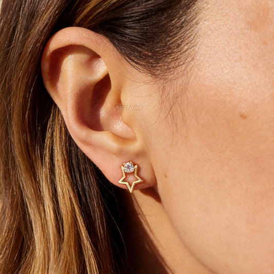 Pair of gold-tone open star-shaped clip-on earrings featuring a small clear crystal and comfortable invisible coil back closures.