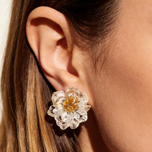 Pair of clear resin flower clip-on earrings containing real dried white and yellow flowers with silver-tone adjustable coil backings.