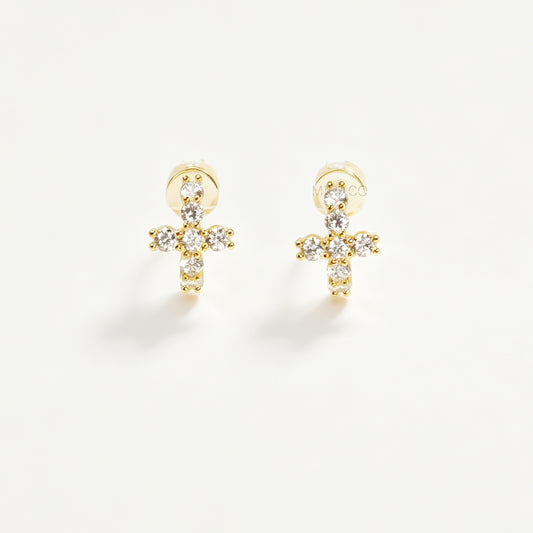 A pair of gold-tone clip-on hoop earrings shaped like crosses, embellished with clear round crystals and featuring translucent round silicone comfort pads on the back.