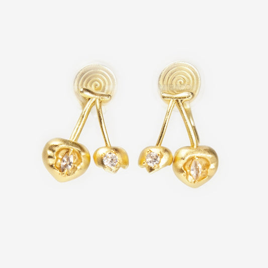 A pair of matte gold cherry-shaped clip-on earrings with small embedded crystals, featuring gold-tone adjustable coil-spring backs for comfortable wear.