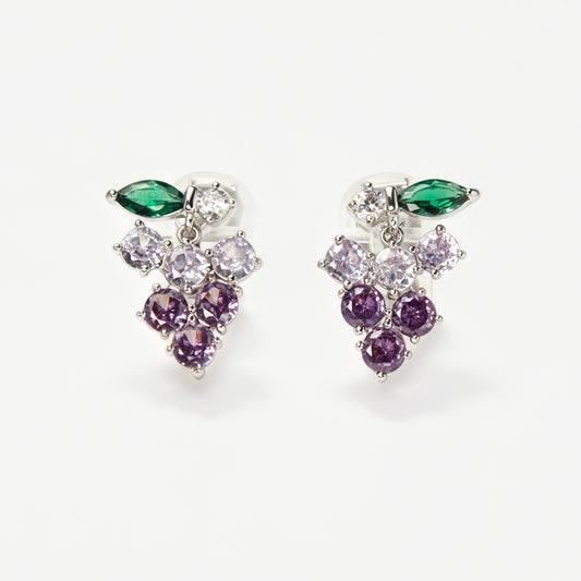 A pair of silver-tone clip-on earrings in the shape of a grape cluster, featuring various shades of round purple crystals and a green marquise-cut crystal leaf
