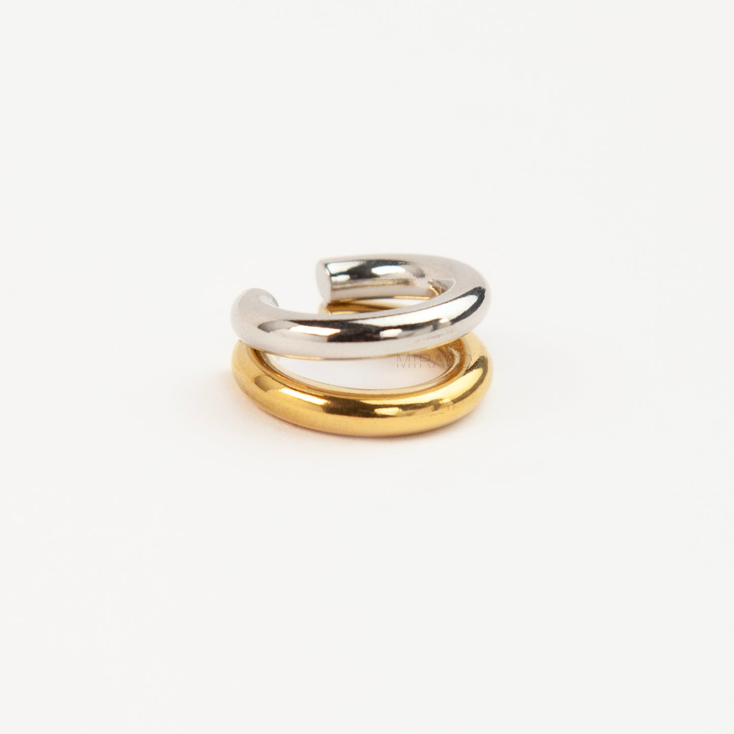 A minimalist two-tone double band ear cuff combining a polished silver hoop stacked with a gold hoop