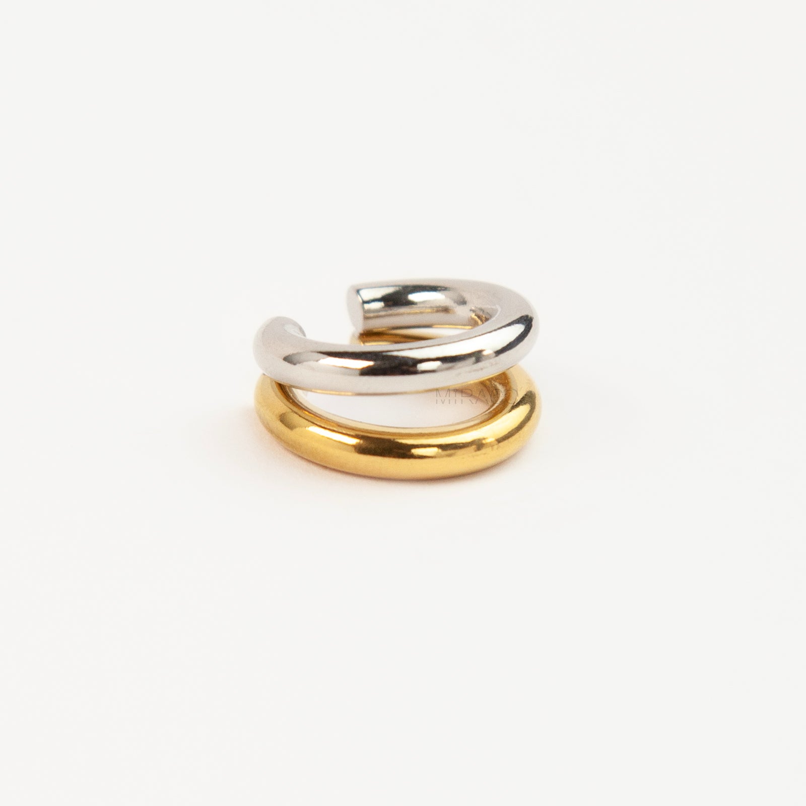A minimalist two-tone double band ear cuff combining a polished silver hoop stacked with a gold hoop