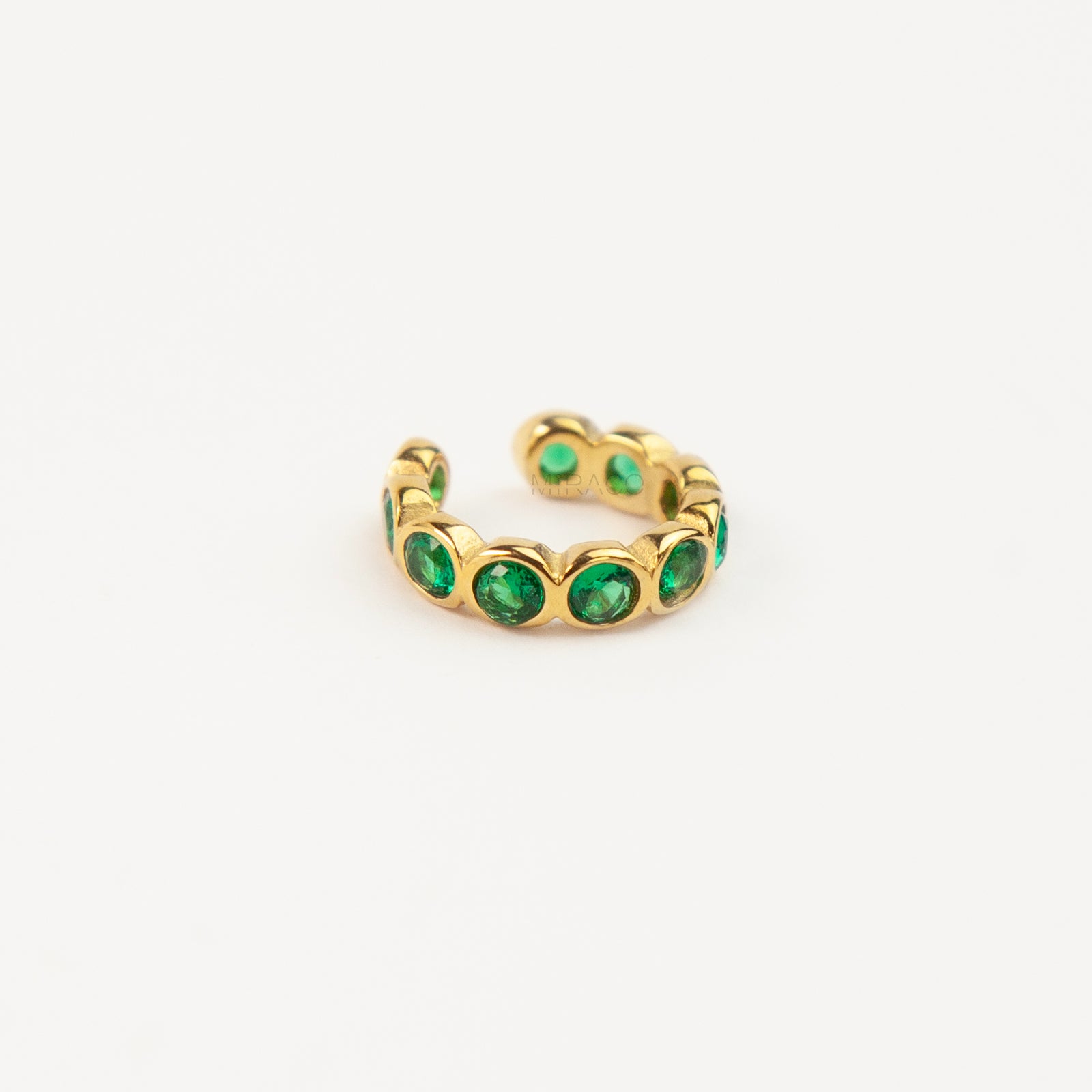 single eternity ear cuffs with bezel-set stones, gold with emerald green crystals.