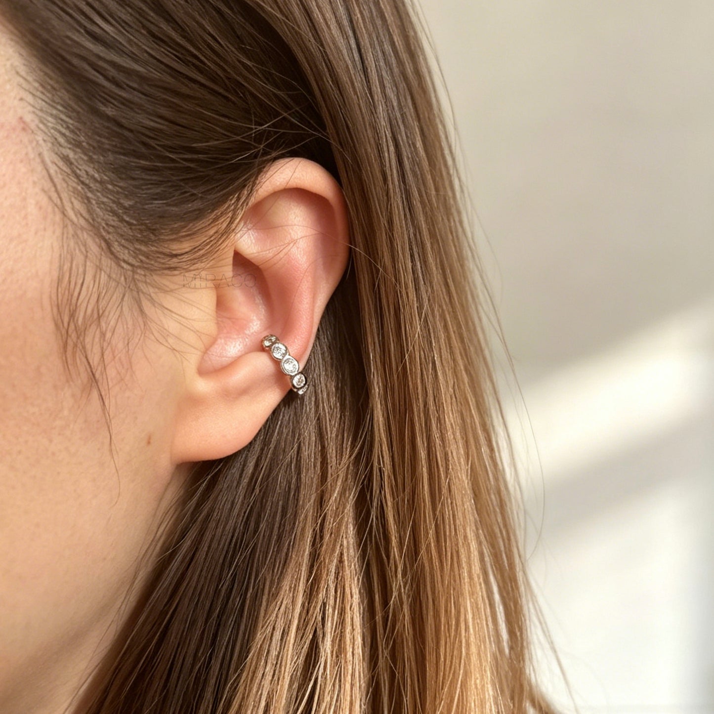 single eternity ear cuffs with bezel-set stones, including one silver with clear crystals