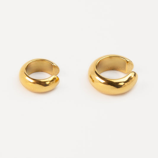 Two chunky, polished gold-tone stainless steel ear cuffs with a smooth, rounded dome design, displayed side-by-side in different sizes on a white background.