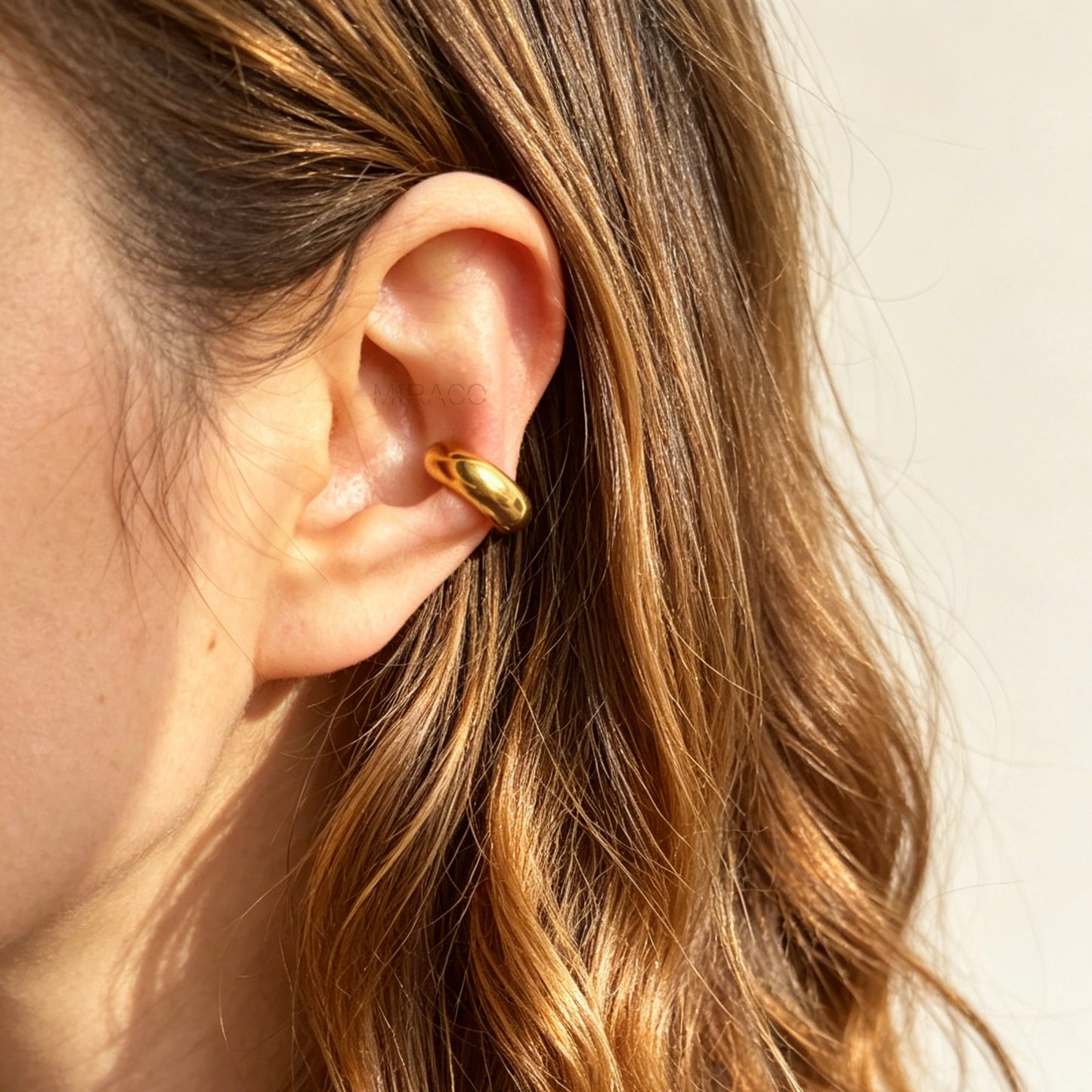 chunky, polished gold-tone stainless steel ear cuffs with a smooth, rounded dome design