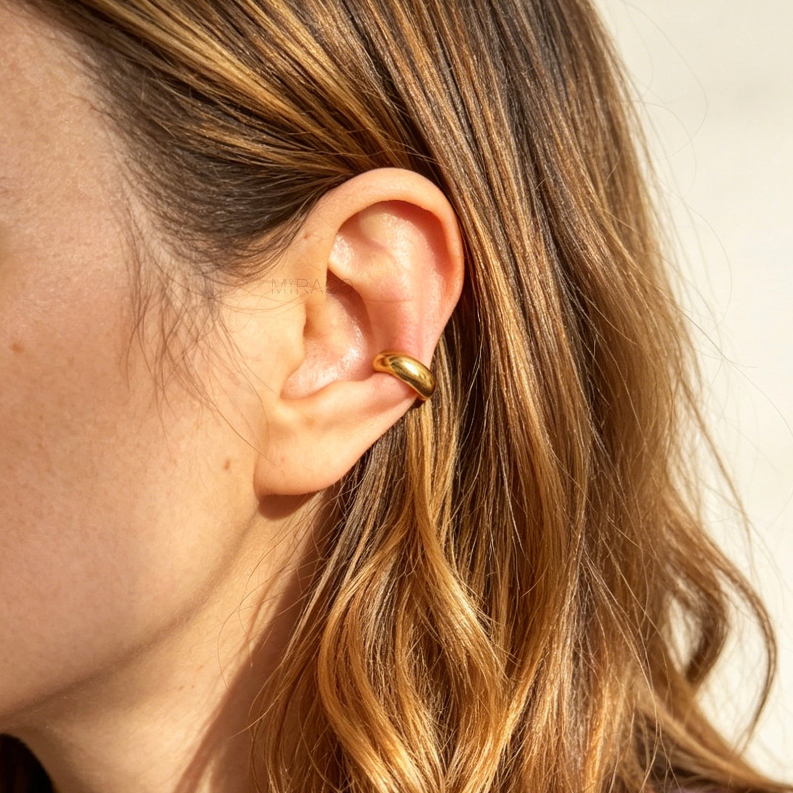 chunky, polished gold-tone stainless steel ear cuffs with a smooth, rounded dome design