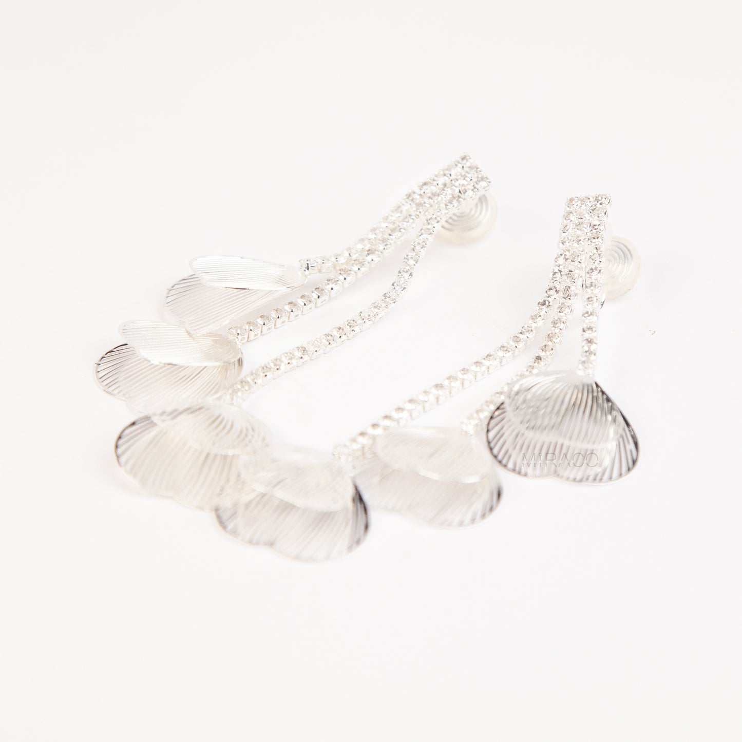A pair of elegant silver dangle clip-on earrings, featuring three rows of sparkling rhinestones cascading into textured, hollow metallic leaf elements hanging in tiers.
