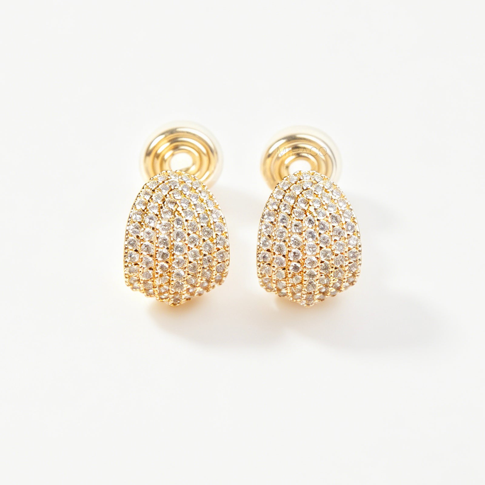 A pair of luxurious gold-plated dome clip-on earrings, heavily encrusted with rows of sparkling pave cubic zirconia crystals, featuring comfortable, adjustable spiral coil backs for non-pierced ears.