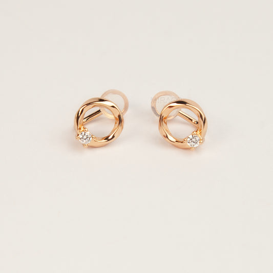 A pair of gold open circle stud clip-on earrings accented with a single sparkling round crystal and fitted with comfortable coil backs with clear silicone cushions.
