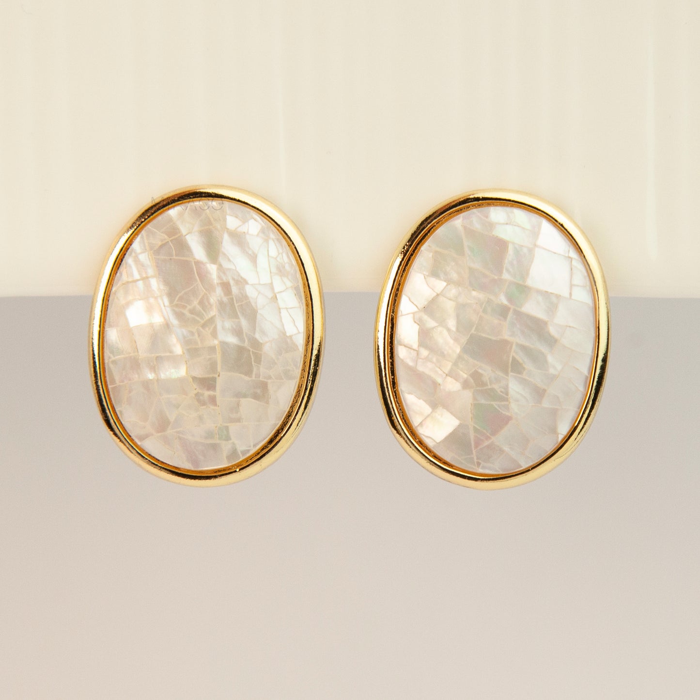 Pair of oval gold-tone non-pierced clip-on earrings with mini clip backs, set with iridescent white mother of pearl shell mosaic inlay.