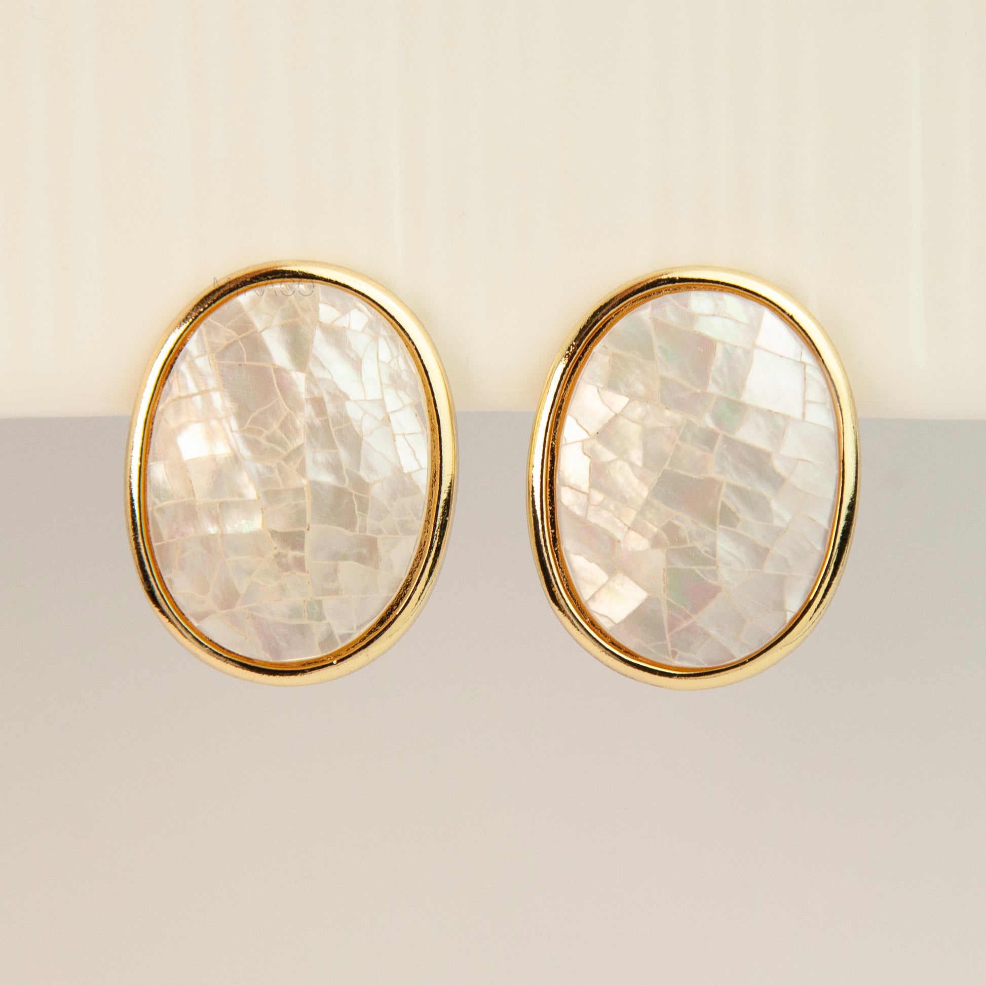 Pair of oval gold-tone non-pierced clip-on earrings with mini clip backs, set with iridescent white mother of pearl shell mosaic inlay.
