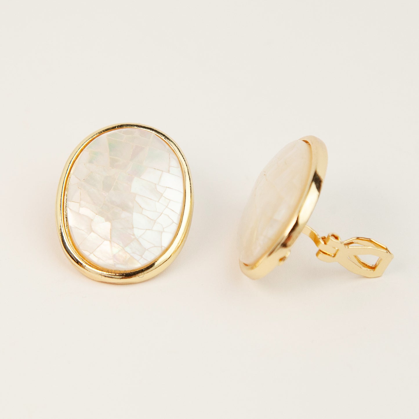 Pair of oval gold-tone non-pierced clip-on earrings with mini clip backs, set with iridescent white mother of pearl shell mosaic inlay.