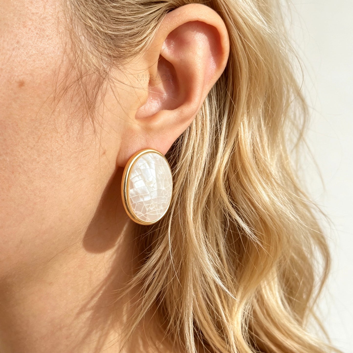 Pair of oval gold-tone non-pierced clip-on earrings with mini clip backs, set with iridescent white mother of pearl shell mosaic inlay.