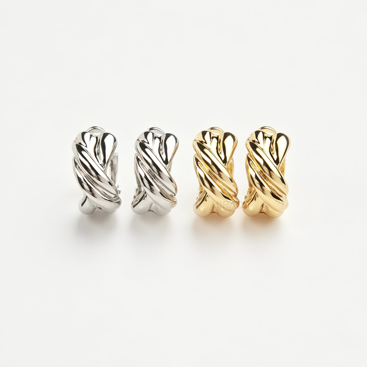 Chunky twisted crossover clip-on hoop earrings with paddle backs displayed in silver and gold tones.