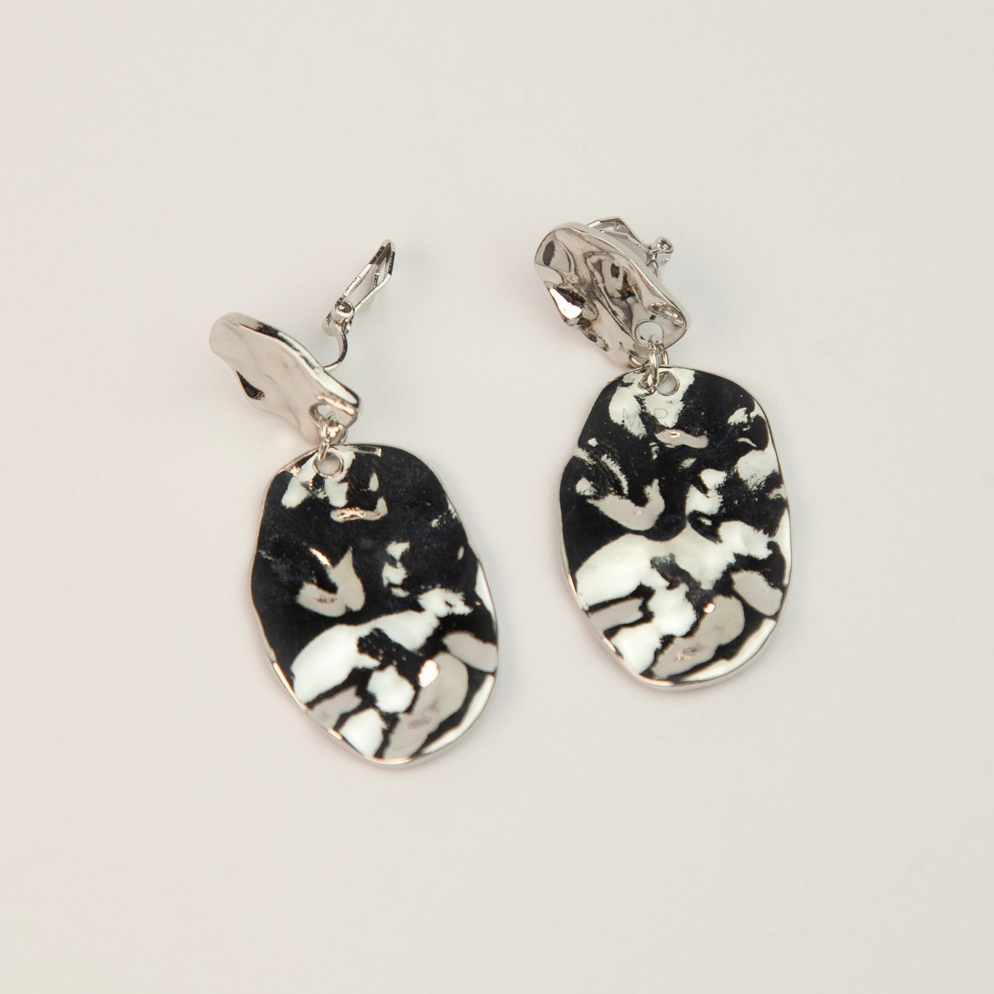 Gold and silver non-pierced statement clip-on earrings with mini clip backs, featuring hammered textured oval metal drop discs.